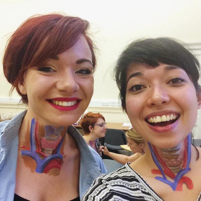 Photo of two medical illustrators with anatomy painted on their necks